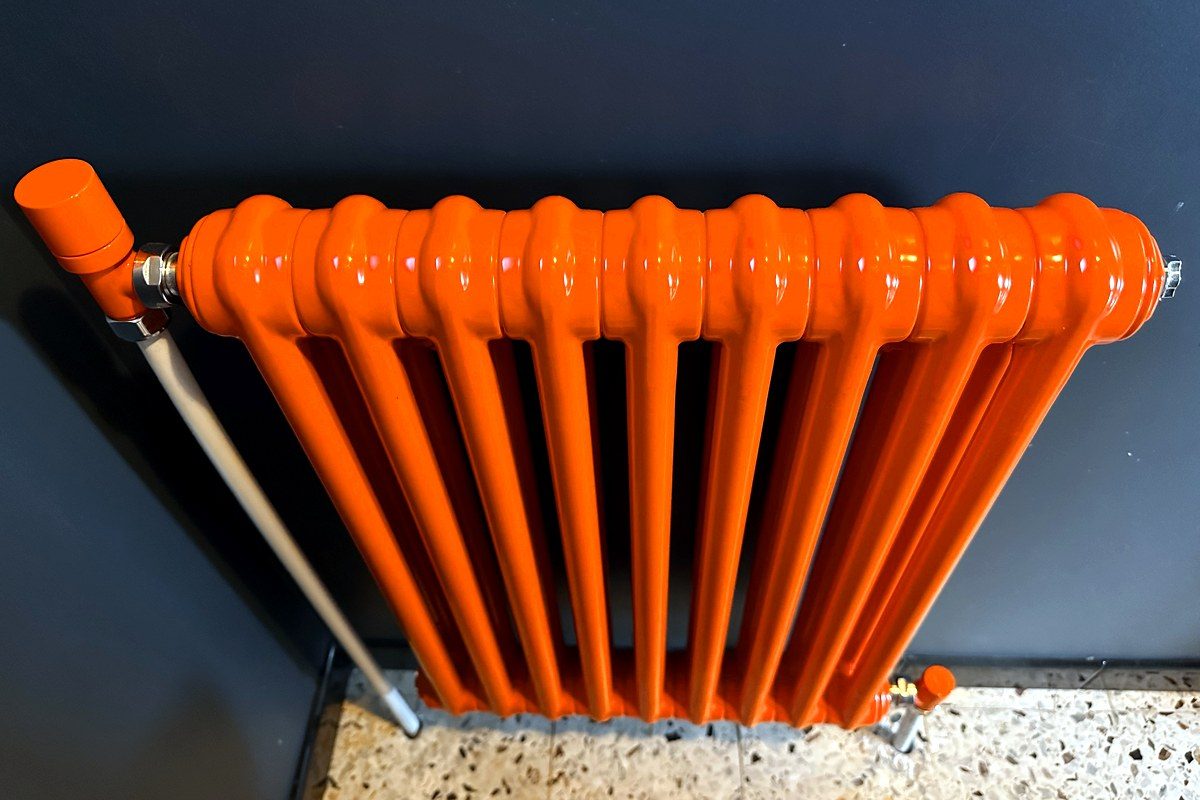 Radiateur en fonte laqué orange avec robinetterie assortie